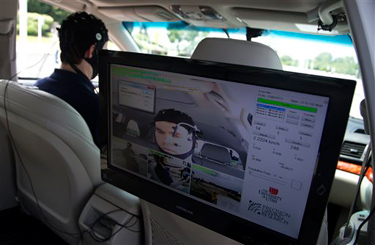 Russ Martin of American Automobile Association (AAA), is seen on a monitor in a research vehicle skull cap to the research vehicle during a demonstration in support of their new study on distracted driving in Landover, Md., Tuesday, June 11, 2013. (AP Photo/Manuel Balce Ceneta)