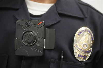 A Los Angeles Police officer wears an on-body cameras during a demonstration for media in Los Angeles Wednesday, Jan. 15, 2014. Police officers assigned to foot patrols of downtown Los Angeles began wearing the cameras on Wednesday as the city evaluates different models to include in its policing.