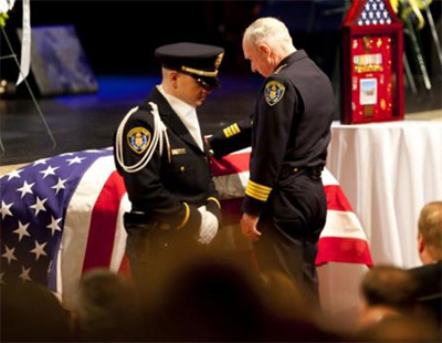 Police Chief William Lansdowne at the casket of Officer Jeremy Henwood, who was shot in an unprovoked attack during a routine police patrol in San Diego.
