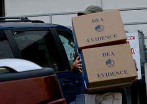 A law enforcement officer carries away evidence from a raid Tuesday at a West Hollywood medical marijuana dispensary.