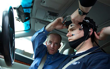 Russ Martin of triple A, is assisted by Joel Cooper, left, hooking the electroencephalographic (EEG)-configured skull cap to the research vehicle during a demonstration in support of their new study on distracted driving in Landover, Md., Tuesday, June 11, 2013. (AP Photo/Manuel Balce Ceneta)