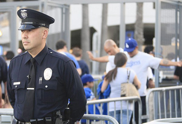 Officer Eddie Salazar watches as fans enter Dodger Stadium after security was increased due to the beating of a Giants fan on opening day. (Gary Friedman/Los Angeles Times / April 16, 2011)