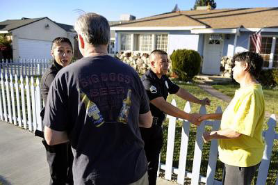 LAPD Sgts. Ruthann Scott and Jose Torres talk with Granada Hills residents after arresting a parolee. The Devonshire Division is trying to cut crime 15 percent by focusing on a small area responsible for 35 percent of crime in the division. (Michael Owen Baker/Staff Photographer)