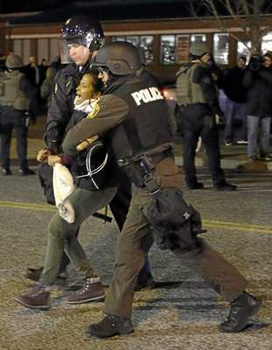 A protester is taken into custody Friday, Nov. 28, 2014, in Ferguson, Mo. Several protesters have been taken into custody during a demonstration outside the police department. Tensions escalated late Friday during an initially calm demonstration after police said protesters were illegally blocking West Florissant Avenue. <i>(AP Photo/Jeff Roberson)</i>