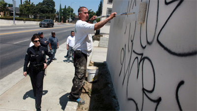 Monica Almeida/The New York TimesOfficer Tracy A. Hauter of the Los Angeles Police Department worked with a crew to identify and paint over graffiti.