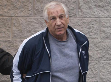 By Andy Colwell, APFormer Penn State football coach Jerry Sandusky is escorted by state police Dec. 7.