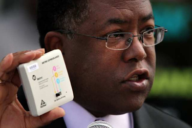 L.A. County Supervisor Mark Ridley-Thomas displays a FasTrak device in July. (Bob Chamberlin / Los Angeles Times)