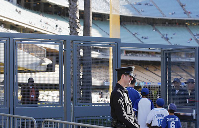 An LAPD officer stands at an entrance to Dodger Stadium before the start of the May 18 game against the Giants. The team had reduced security measures in recent years and now faces a lawsuit from the family of Giants fan who was brutally beaten in the parking lot. (Luis Sinco / Los Angeles Times / May 18, 2011)