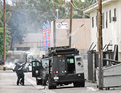 Los Angeles police officers fire tear gas into a Van Nuys apartment unit as they search for a reported second gunman after an LAPD helicopter was fired upon, forcing it to make an emergency landing. No second gunman was found. (Ringo H.W. Chiu, for The Los Angeles Times / April 24, 2011)