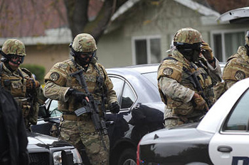 Modesto police officers prepare to enter the scene of a shooting on Thursday in Modesto, Calif. A sheriff's deputy and a civilian were killed when gunfire broke out as authorities tried to serve an eviction notice at an apartment complex, officials said.Joan Barnett Lee/The Modesto Bee/AP