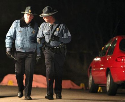 By Jessica Stewart, APKansas State Troopers pass near the covered body of a suspected shooter who shot and killed Sgt. David Enzbrenner on Dec. 9.