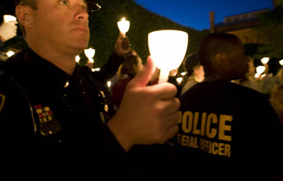 Police officers and relatives hold candles at a ceremony honoring officers killed in the line of duty in 2008.