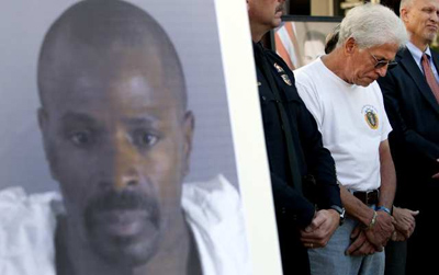 Photo: Joseph Bonaminio, father of Riverside police Officer Ryan Bonaminio, looks down during a 2010 news conference as Police Chief Sergio Diaz announces that Earl Ellis Green of Rubidoux, whose image is at left, was arrested on suspicion of murdering the officer. Credit: Gina Ferazzi / Los Angeles Times