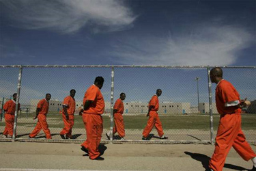 Counties must gain control over the state funds they need to house, supervise, monitor and rehabilitate state prisoners and parolees. Photographed: Inmates walking in the prison yard at the California State Prison-Lancaster on June 10, 2010. (Los Angeles Times)