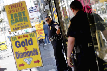 Armed security guard Arturo Midence, 42, stands in front of three downtown L.A. jewelry stores he guards near the corner of Broadway and 6th Street. The LAPD has investigated 10 smash-and-grab robberies in the downtown jewelry district this year. (Jay L. Clendenin, Los Angeles Times)