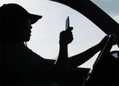 Texting while driving. 2009 photo by Robert F. Bukaty, AP