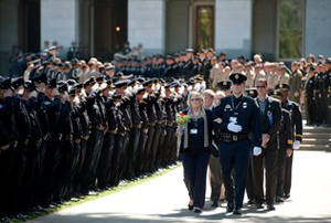 Randy Pench / rpench@sacbee.comBeverley Henwood, center, mother of slain San Diego Officer Jeremy Henwood, is escorted from the Capitol to a ceremony where Gov. Jerry Brown and other state officials spoke.