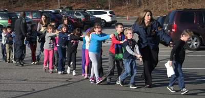 In this Friday, Dec. 14, 2012 file photo provided by the Newtown Bee, Connecticut State Police lead a line of children from the Sandy Hook Elementary School in Newtown, Conn. after a shooting at the school. (AP Photo/Newtown Bee, Shannon Hicks)