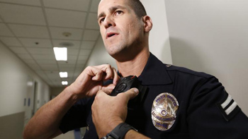 LAPD Officer Jim Stover demonstrates his new body camera at Mission Division headquarters in August. (Al Seib / Los Angeles Times)