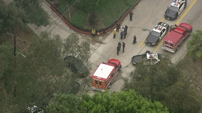  ( KTLA-TV / March 24, 2014 )SWAT officers surround the Hollywood Hills home of a man suspected of shooting at two LAPD officers Monday, injuring one of them.