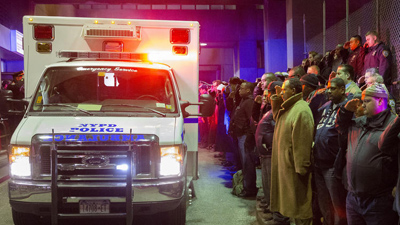 Mourners stand at attention as the bodies of Officers Rafael Ramos and Wenjian Liu are carried off in an ambulance.<i>(John Minchillo / Associated Press)</i>